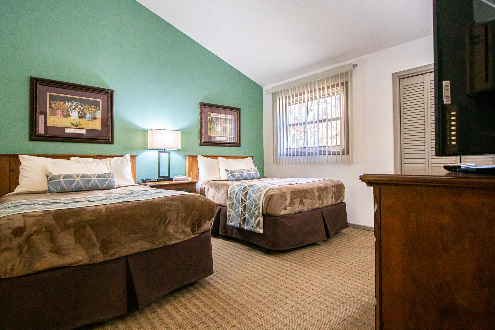 A spacious bedroom with double beds at VRI's Fox Run Resort in North Carolina.